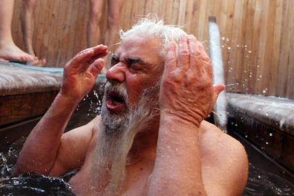Мужчина окунается в воду на Крещение в святой купели на чудотворном источнике в деревне Витовка.