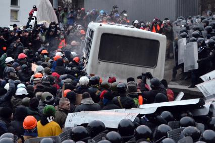 Столкновение протестующих и бойцов спецподразделения `Беркут`. Протестующие раскачивают автобус.