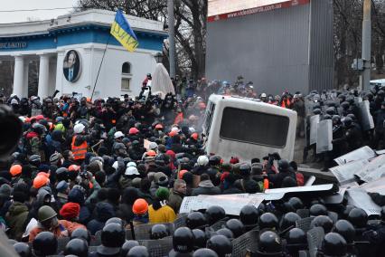 Столкновение протестующих и бойцов спецподразделения `Беркут`. Протестующие раскачивают автобус.