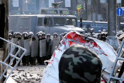 Противостояние, протестующий стоит за барикадами напротив бойцов специального подразделения `Беркут`.