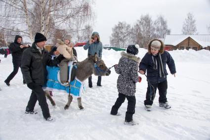 Масленичные гулянья в Суздали. Ребнка катают на осле.