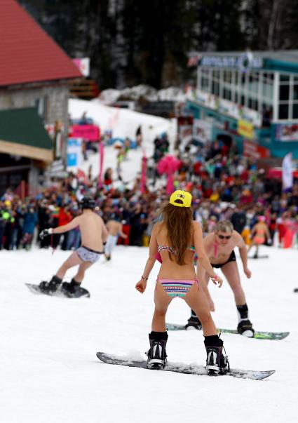 В рамках `Фестиваля весеннего солнцекатания` состоялся спуск полуголых лыжников и сноубордистов. На снимке: женщина в купальнике на сноуборде.
