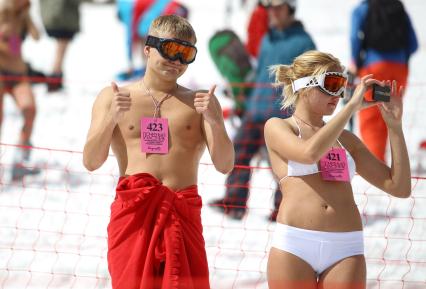 В рамках `Фестиваля весеннего солнцекатания` состоялся спуск полуголых лыжников и сноубордистов. На снимке: мужчина и женщина в купальных костюмах.