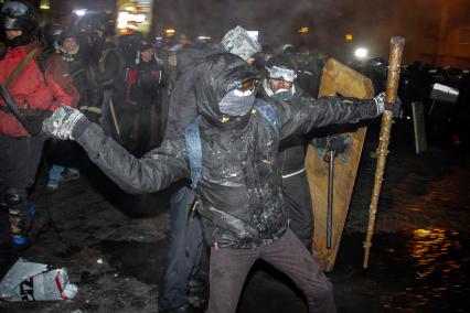 Протестующие штурмуют Украинский дом. На снимке: протестующий бросает камень.