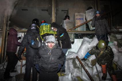 Протестующие штурмуют Украинский дом. На снимке: протестующие и бойцы специального подразделения `Беркут` у входа в здание ведут.