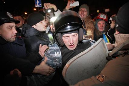 Конфликт между протестующими и бойцами спецподразделения `Беркут`возле Святошинского РОВД. На снимке: бойцы `Беркута` отбиваются от протестующих.