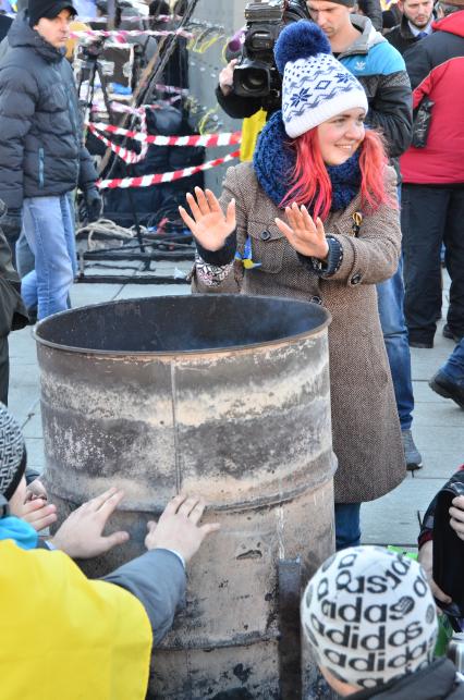 Евромайдан. Акция сторонников Евроинтеграции.    На снимке: девушка греется у бочки