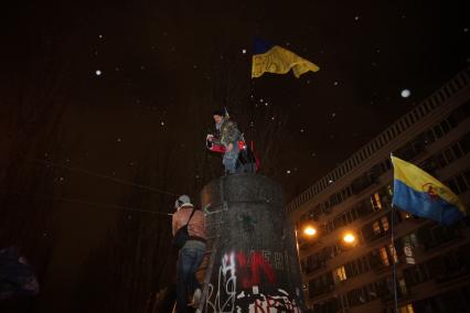 Протестующие с украинским флагом на постаменте памятника В. Ленину.