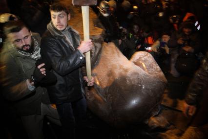 Протестующие ломают памятник В. Ленину.