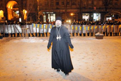 Силовой разгон пикетов в Киеве. На снимке: бойцы специального подразделения `Беркут` со щитами в буках и священник перед ними.