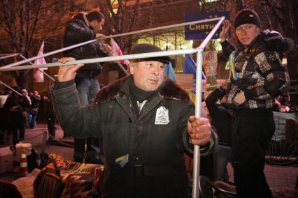 Протестующие собирают палатку.