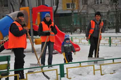 Гастарбайтеры на детской площадке с ребенком.