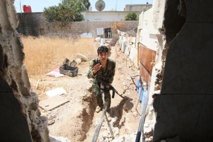 Дераа. Операция сирийских военных по зачистке города от боевиков. На снимке: сирийский солдат преодолевает открытое пространство бегом.