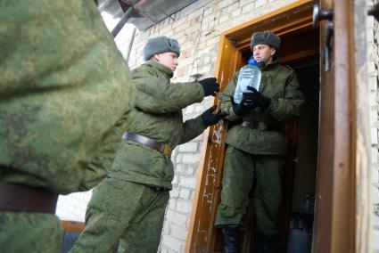 Армия помогает жителям города с подвозом воды. На снимке: солдаты складируют питьевую воду в пластиковых бутылках.