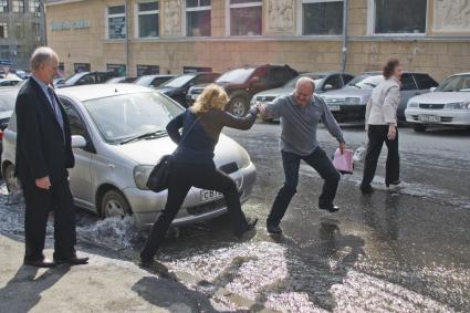 Люди переходят затопленную улицу.