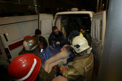 В московском `Трансвааль-парке`произошло обрушение крыши, в результате 28 человек погибли и 193 получили ранения. На снимке: спасатели заносят пострадавшую женщину в машину скорой помощи.