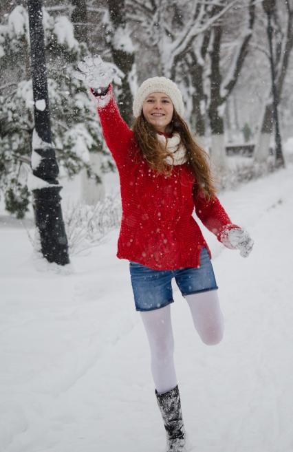 Девушка играет в снежки.