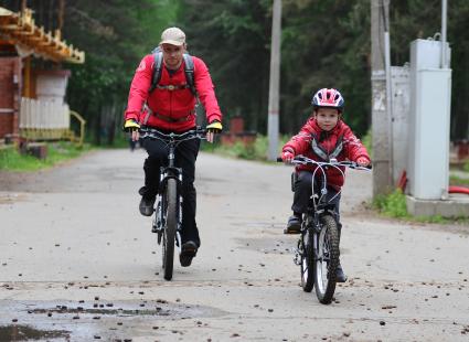 Мужчина с ребенком на велосипеде.