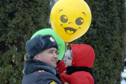Празднование масленицы в Туле. На снимке: Полицейский держит на руках ребенка который держит надувные шарики.