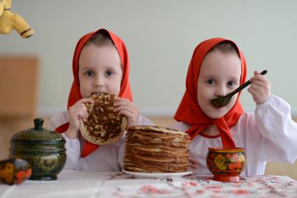 Масленица. На снимке: девочки-близняшки угощают блинами.