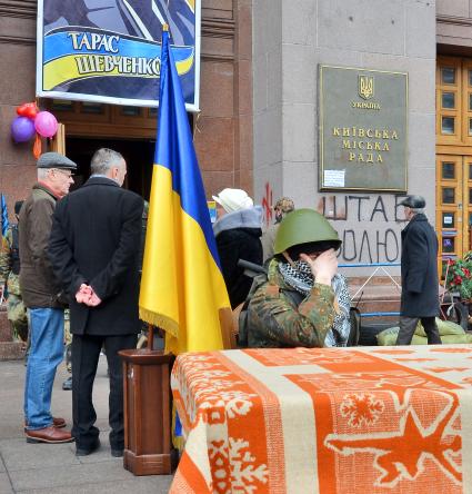 Захват Киевской городской государственной администрации сторонниками радикальной оппозиции. Вход в здание украшен портретов Тараса Шевченко, у входа сидит охранник, стоит флаг Украины.