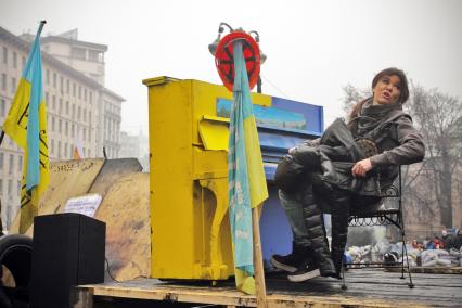 Украинская певица Руслана Лыжичко играет на пианино раскрашенном в цвета государственного флага Украины во время протестов в Киеве.