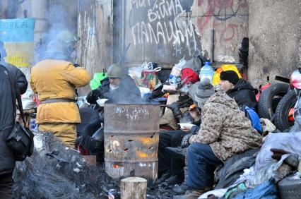 Сторонники радикальной оппозиции едят на улице во время беспорядков в Киеве.