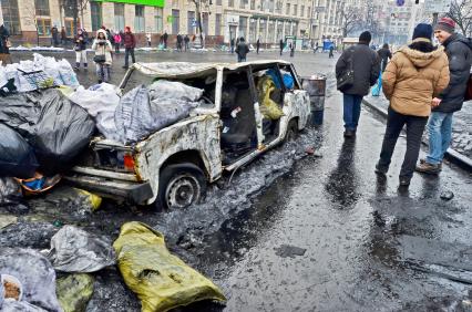 Искореженный автомобиль на улице во время беспорядков в Киеве.