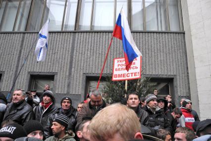 Беспорядки у здания парламента Крыма в Симферополе. Люди с российским государственным и андреевским флагомами на площади у парламента. Плакат с надписью: `Украина, Россия, Беларусь вместе!`