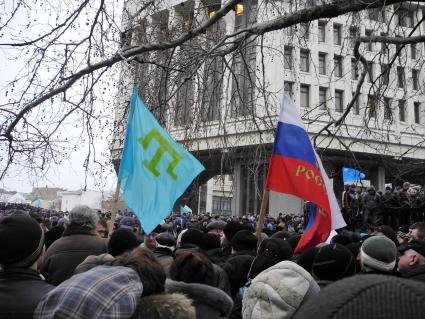 Беспорядки у здания парламента Крыма в Симферополе. Флаг крымских татар и флаг России в толпе перед зданием парламента.