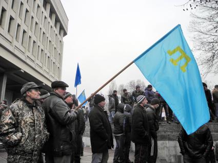 Беспорядки у здания парламента Крыма в Симферополе. Крымские татары у здания парламента с флагом в руках.