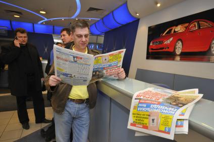 Мужчина читает газету `Комсомольская правда`.