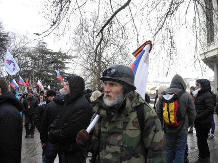 Митинг у здания парламента Крыма в Симферополе Мужчина в камуфляже с российским флагом.