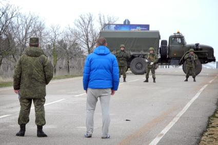 Блок-пост на дороге ввиде грузового автомобиля посередение дороги контролируемый военными.