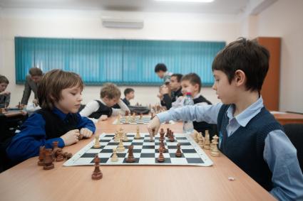 Дети играют в шахматы в Уральской шахматной академии провел сеанс одиночной игры.
