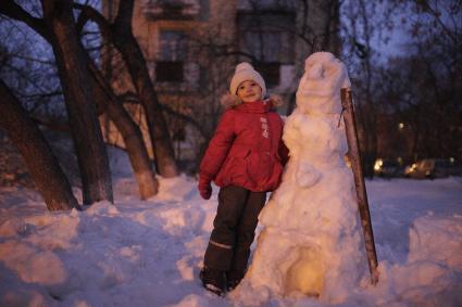 Девочка рядом со снеговиком.