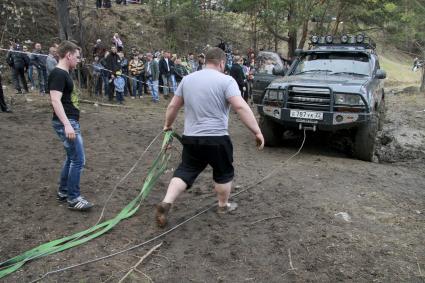 Джип-спринт `Апрельский кураж` в Барнауле. На снимке: мужчины готовятся вытаскивать автомобиль из грязи.