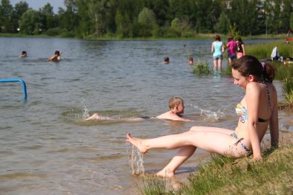 Девушка в купальнике на городском пляже.