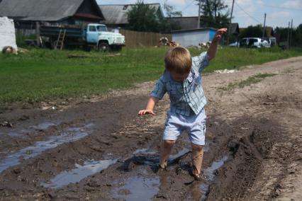 Ребенок в дорожной грязи.