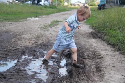 Ребенок в дорожной грязи.