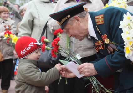 Ветеран разговаривает с ребенком.