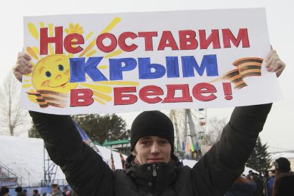 Митинг в поддержку поддержка Крыма в Барнауле. На снимке: митингующий с плакатом: `Не оставим Крым в беде!`.
