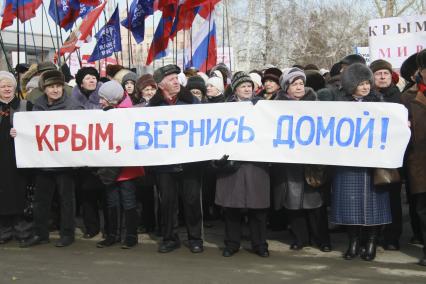 Митинг в поддержку поддержка Крыма в Барнауле. На снимке: митингующий с плакатом: `Крым, вернись домой!`.