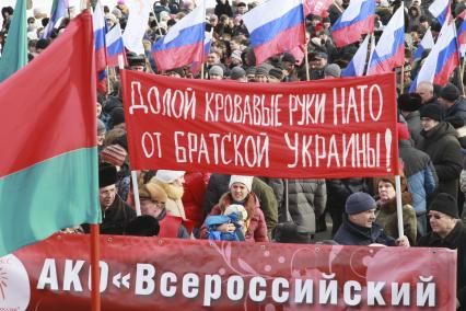 Митинг в поддержку поддержка Крыма в Барнауле. На снимке: митингующий с плакатом: `Долой кровавые руки НАТО от братской Украины!`.