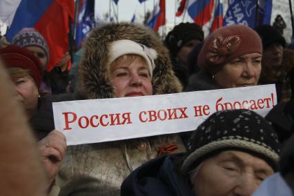 Митинг в поддержку поддержка Крыма в Барнауле. На снимке: митингующий с плакатом: `Россия своих не бросает!`.