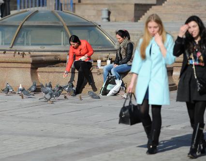 Манежная площадь. На снимке: девушка кормит голубей.