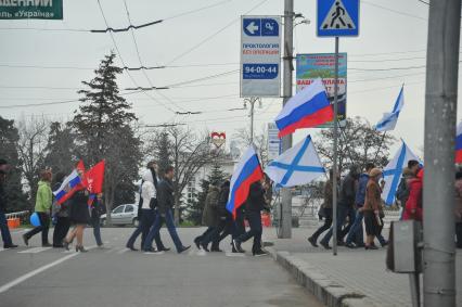 Референдум о статусе Крыма. Севастополь. На снимке: люди с российскими и андреевскими флагами идут по улице.