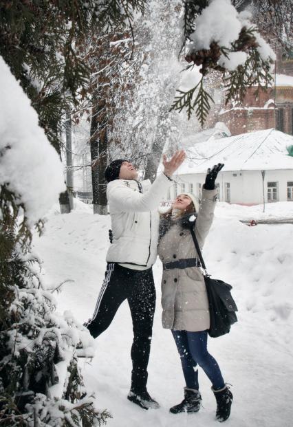 Парень и девушка радуются снегу.