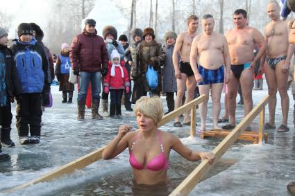 Женщина окунается в проруби на крещение.