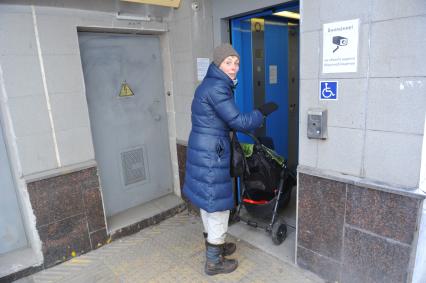 Ленинградское шоссе. На снимке: женщина с ребенком в детской коляске у лифта для людей с ограниченными возможностями в подземном переходе.